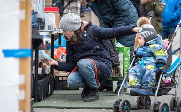 Alona sieht sich die Vorräte an einem der Stände der Hilfsorganisationen am Nyugati-Bahnhof in Budapest an. Sie, ihr eineinhalbjähriger Sohn und ihre Mutter flohen aus Kiew und kamen am 6. März nach einer 26-stündigen Reise in Budapest an – Bild: LWB/Albin Hillert
