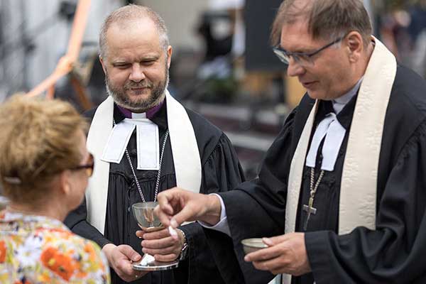 Die Bischöfe Shvarts und Fabiny beim Austeilen des Abendmahls beim gemeinsamen Gottesdienst in Budapest. – Bild: ELKU